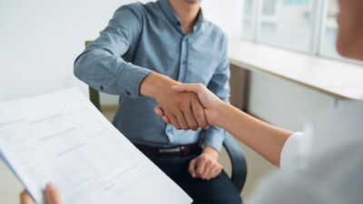 smiling asian businessman shaking partners hand